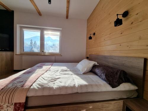 a bedroom with a large bed with a window at Karpielówka 77 pokoje gościnne in Kościelisko