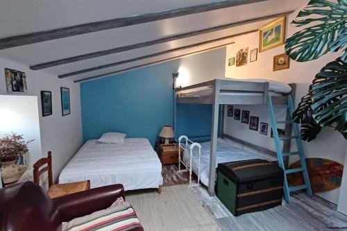 een slaapkamer met een stapelbed en een bank bij Agréable maison de pêcheur, proche île d'Oléron in Bourcefranc