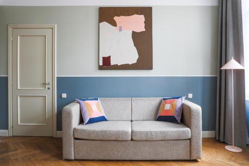 a living room with a couch and a painting on the wall at Numa Prague Flow in Prague