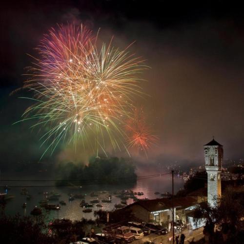 a fireworks display over a body of water with a clock tower at Residence Sala Comacina apartment no 2 with pool and spa by Italian Apartments in Isola Comacina