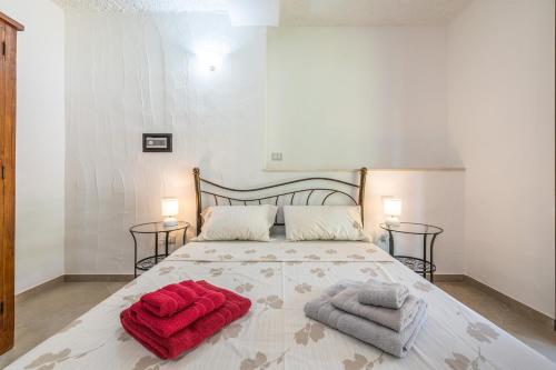 - une chambre avec un lit et des serviettes rouges dans l'établissement Villa Eleonora Residence App to 4, à Capoterra