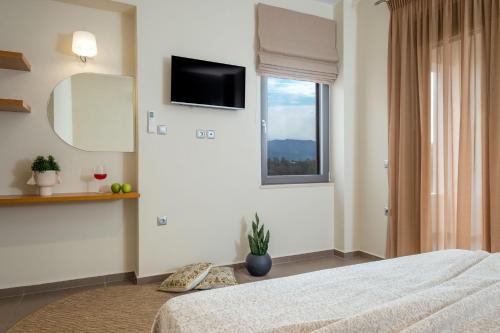 a bedroom with a bed and a television on the wall at Villa Merlin in Galatás