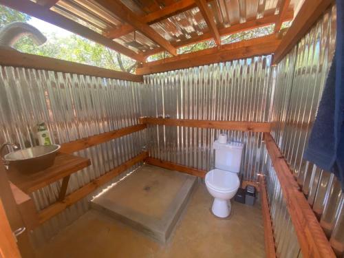 ein Badezimmer mit einem WC in einer Holzkonstruktion in der Unterkunft VlakkiesKraal Bosbok Camp in Bela-Bela