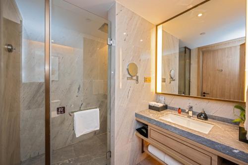 a bathroom with a sink and a shower at Nanan Ao Sheng Yi Hao Hotel in Quanzhou