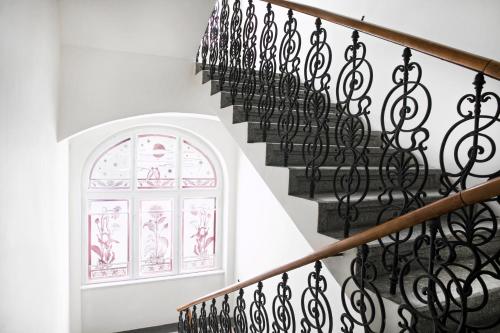 a staircase with wrought iron railings and a window at numa I Flow Rooms & Apartments in Prague