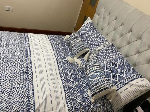 a bed with blue and white pillows on it at Private ensuite room in Birmingham in Birmingham