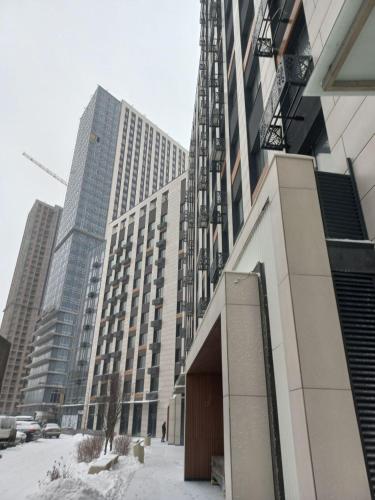 un gran edificio frente a un edificio cubierto de nieve en Апартаменти MYFREEDOM поруч із метро Теремки, en Kiev
