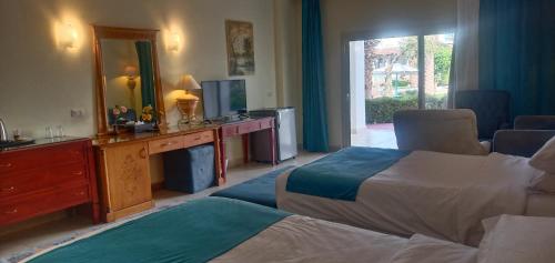 Sharm Bride Resort Aqua & SPA في شرم الشيخ: غرفة فندقية بسريرين ومرآة