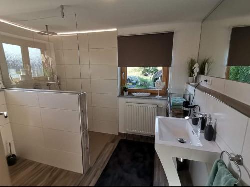 a white bathroom with a sink and a mirror at Hartl Hof in Breitenberg