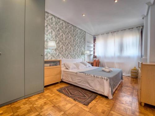 a bedroom with a bed and a large window at APARTAMENTO EN GROS, SAN SEBASTIÁN Zurriola Beach in Donostia-San Sebastián