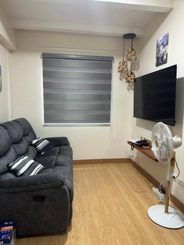een woonkamer met een bank en een flatscreen-tv bij Scandia Suites in Silang