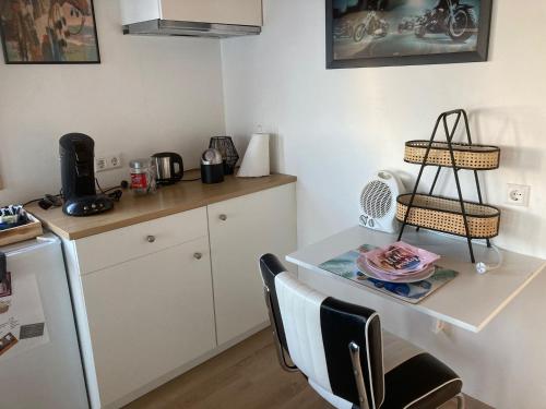 eine Küche mit einem Tisch und einem weißen Kühlschrank in der Unterkunft Bed & Breakfast ‘t Westergouwertje in Gouda