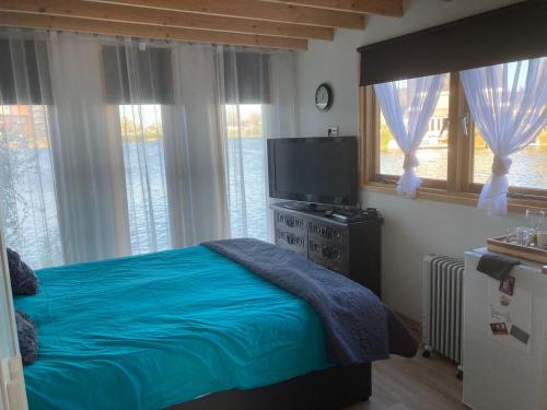 um quarto com uma cama e uma televisão de ecrã plano em Bed & Breakfast ‘t Westergouwertje em Gouda