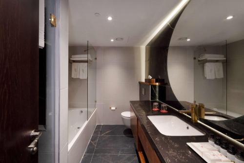 uma casa de banho com um lavatório, um WC e um espelho. em Ramada Jerusalem Hotel em Jerusalém
