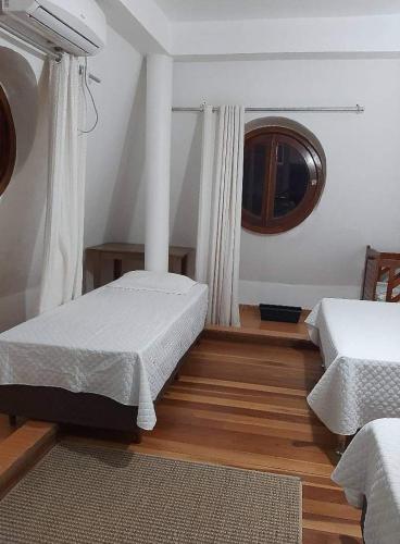 a bedroom with two beds and a window in it at ROSA CORTIANA Escalera in São Gabriel