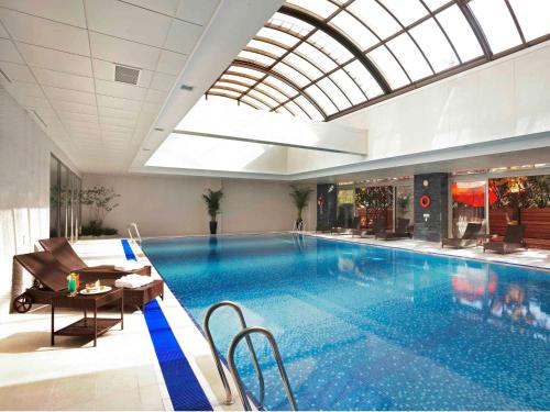 a large swimming pool in a building with a ceiling at Novotel Ambassador Seoul Gangnam in Seoul