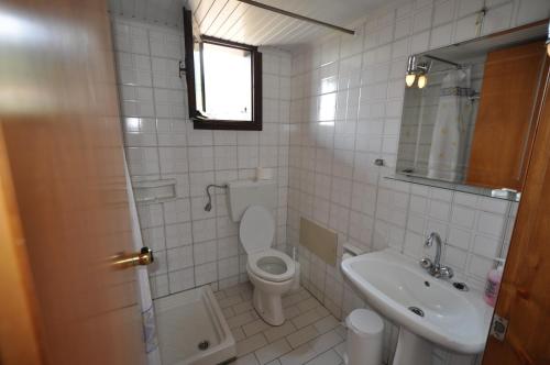 a white bathroom with a toilet and a sink at Hotel Sylvia in Koinyra