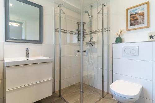 een badkamer met een douche, een toilet en een wastafel bij Deichlamm in Sankt Peter-Ording