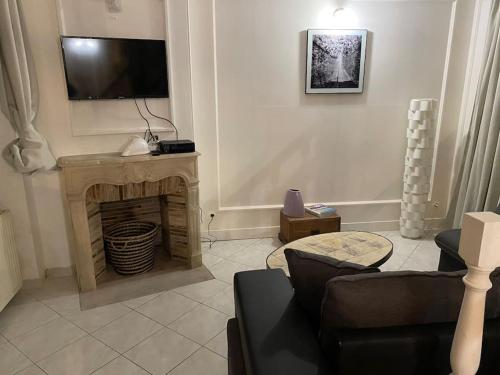 ein Wohnzimmer mit einem TV und einem Kamin in der Unterkunft Maison Ancienne à côté des Champs Elysees in Puteaux