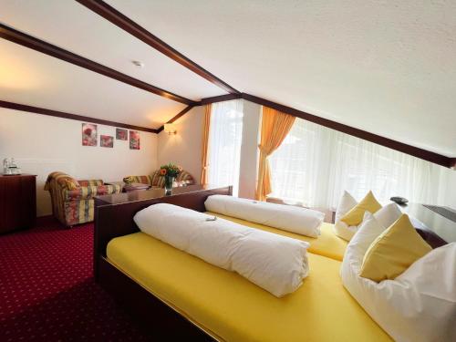 a room with two pillows on a yellow bed at Kurhotel Wiedenmann in Bad Wörishofen