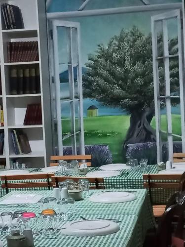 a table with a painting of a tree on the wall at Zarbalı Cunda in Ayvalık