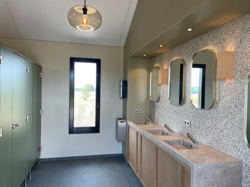 een badkamer met 2 wastafels en 2 spiegels bij Camping de Vliert in Bunnik