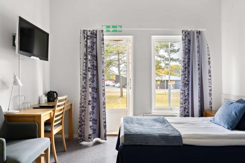 a bedroom with a bed and a desk and a window at Tyleback Hotell; Sure Hotel Collection by Best Western in Halmstad