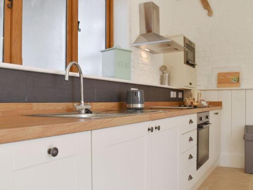 a kitchen with white cabinets and a sink at The Nags Stable - Ukc4136 in Arlingham