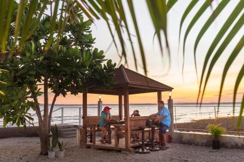 eine Gruppe von Menschen, die in einem Pavillon am Strand sitzen in der Unterkunft Beachfront Mansion and Seascape Villas Calatagan with Outdoor Pool in Calatagan