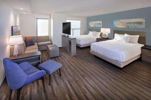 a hotel room with two beds and a chair at Hyatt House Lewes Rehoboth Beach in Lewes