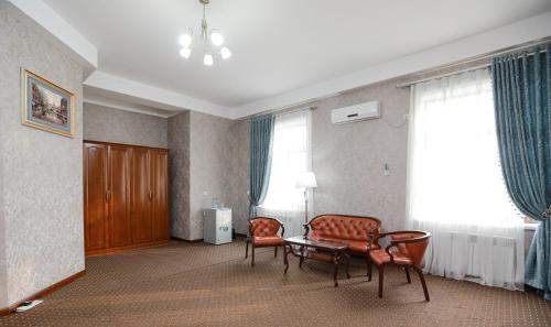 a living room with two chairs and a table at Khujand Grand Hotel in Khujand