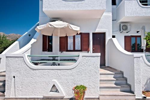 Casa blanca con escaleras y sombrilla en Apartments with garden view1, en Ierápetra