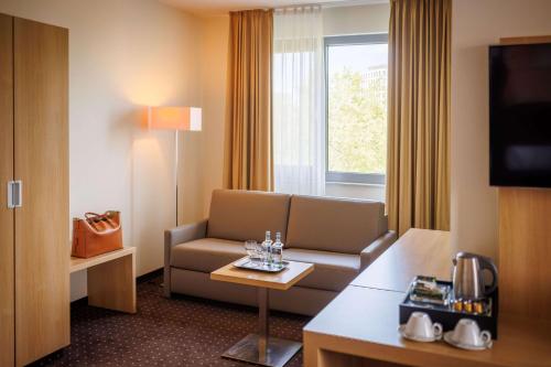ein Hotelzimmer mit einem Sofa und einem Tisch in der Unterkunft Lanzcarré Hotel Mannheim, a member of Radisson Individuals in Mannheim