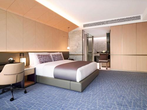 a bedroom with a large bed and a desk and a desk at Fairmont Ambassador Seoul in Seoul