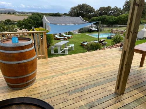 eine Holzterrasse mit einem Fass und einem Pool in der Unterkunft Vinistrella in Kapstadt