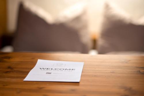 a welcome card sitting on a wooden table at MY HIAS Apartment in Gries im Sellrain