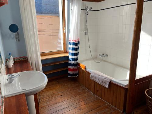 a bathroom with a bath tub and a sink at Le Passage in Concarneau