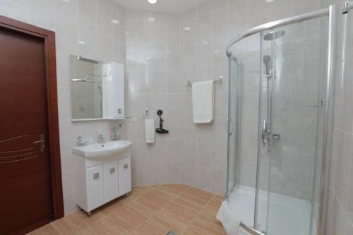 a bathroom with a shower and a sink at Khujand Grand Hotel in Khujand