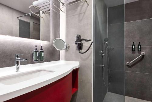 uma casa de banho com um lavatório e um chuveiro em Ramada Resort By Wyndham Kizkalesi em Kizkalesi