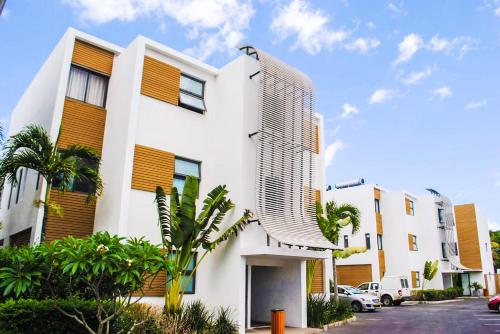a white building with a tall building at Cap Ouest Luxury Beachfront in Flic-en-Flac