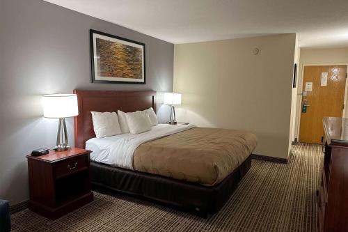 a hotel room with a bed and two lamps at Baymont by Wyndham South Bend Near Notre Dame in South Bend