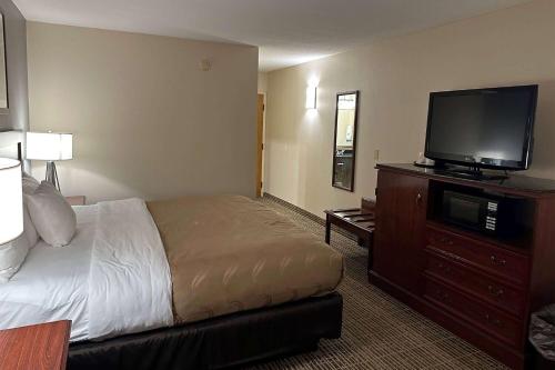 a hotel room with a bed and a flat screen tv at Baymont by Wyndham South Bend Near Notre Dame in South Bend