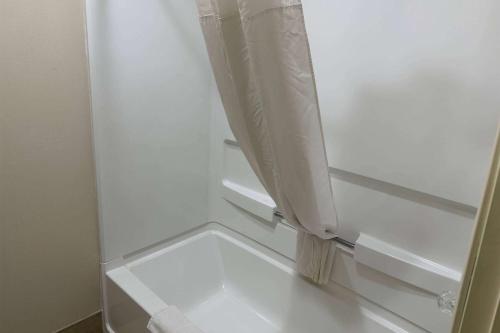 a white refrigerator with a shower curtain in a room at Baymont by Wyndham South Bend Near Notre Dame in South Bend