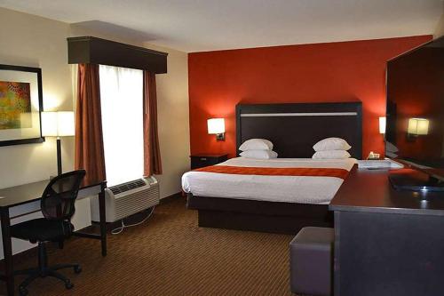 una camera d'albergo con letto e scrivania di Days Inn by Wyndham Laurel MS a Laurel