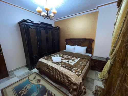 une chambre avec un lit avec une tête de lit en bois dans l'établissement Spacious and Luxury Family Apartment Full Pyramids view, au Caire
