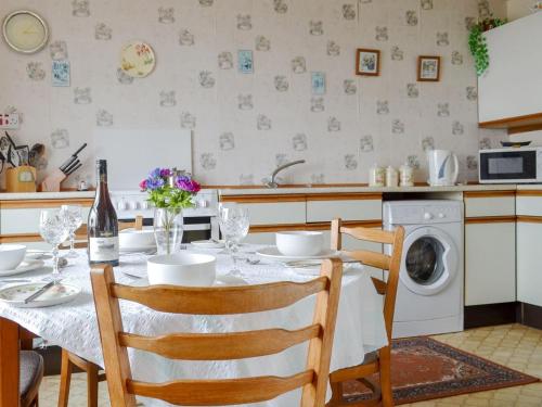 - une cuisine avec une table et un lave-linge dans l'établissement Tigh Mairi, à Tarbert