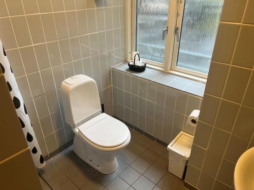 a bathroom with a toilet and a window at Hotel 9 små hjem in Copenhagen