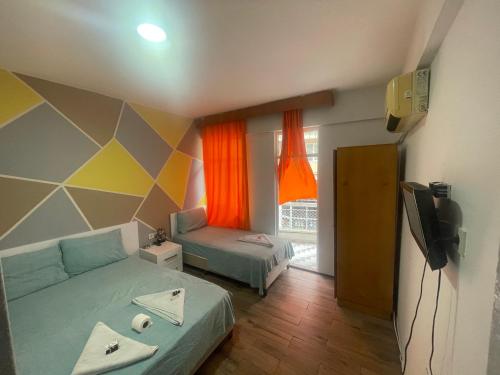 a room with two beds and a television in it at Ersoy Ak Pansiyon in Antalya