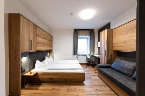 pokój hotelowy z 2 łóżkami i kanapą w obiekcie Familiengut Ertlhof w mieście Seeboden