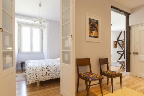 a bedroom with a bed and two chairs in a room at ALTIDO Inviting flat next to Carmo Convent in Lisbon